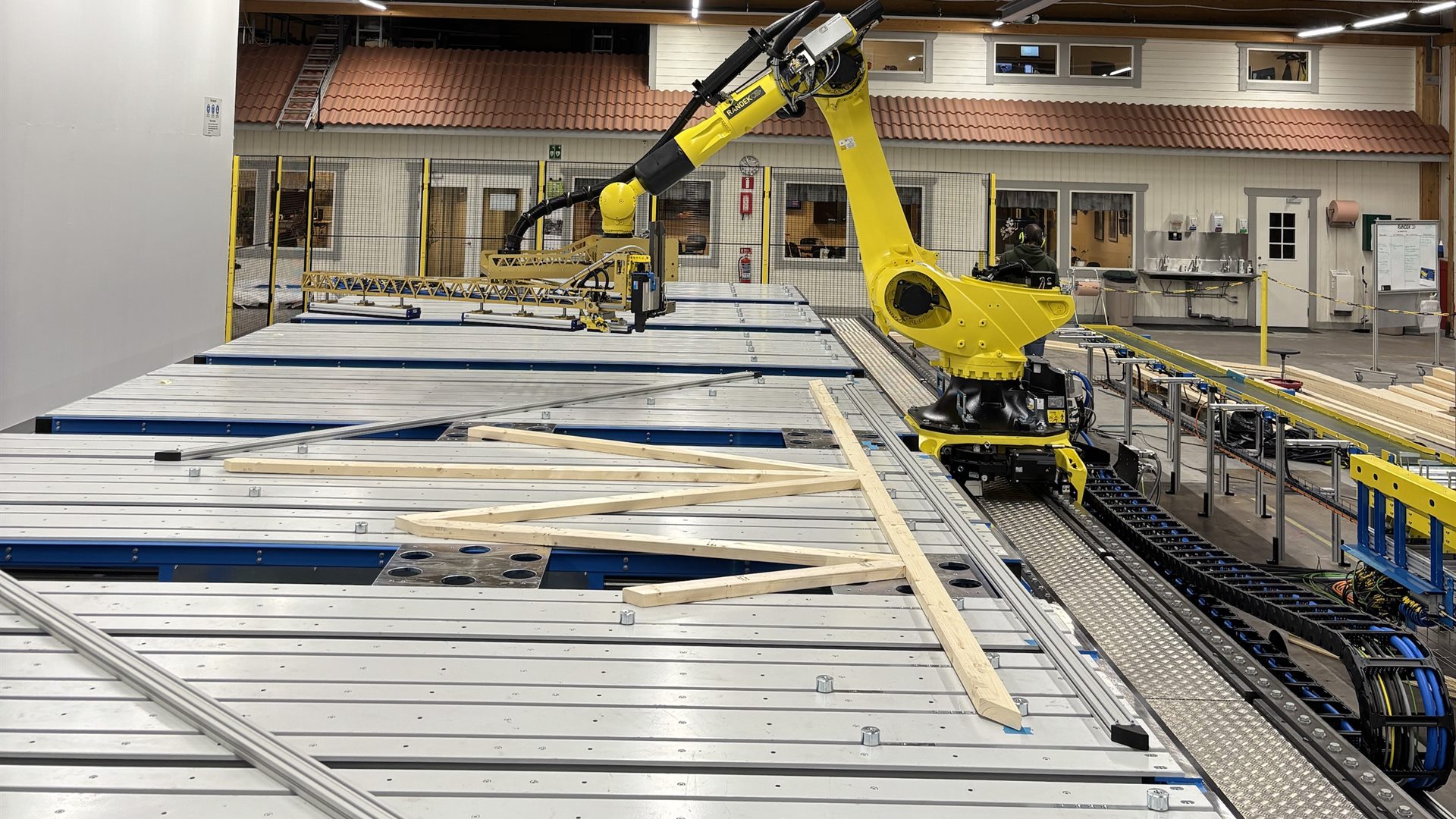 Robot placing timber on a Randek roof truss line