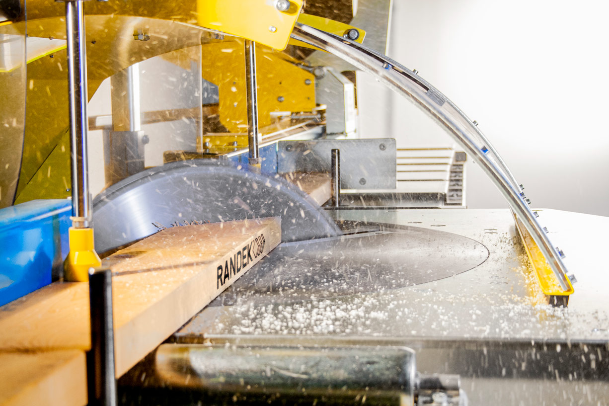 The SPL728 saw blade cutting through a Randek-branded stud, sawdust in the air